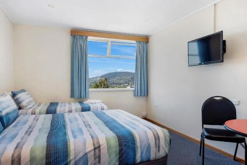 una camera d'albergo con due letti e una finestra di Marquis Hotel Motel a Hobart