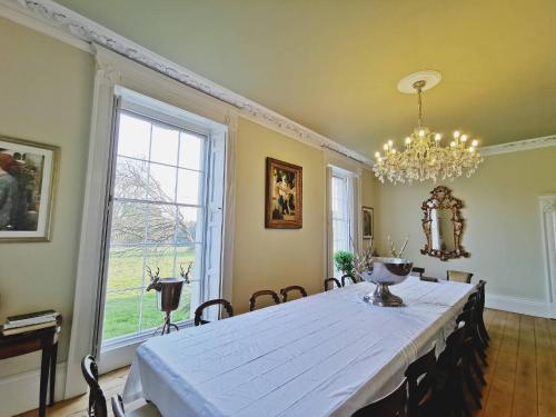 Severn Manor Country Estate في Astley: غرفة طعام مع طاولة بيضاء وثريا