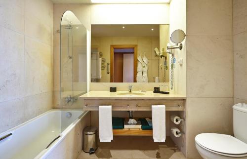 a bathroom with a sink, toilet and bathtub at PortoBay Serra Golf in Santo António da Serra