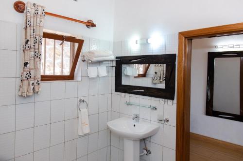 uma casa de banho branca com um lavatório e um espelho em Room in Guest room - Rushel Kivu Resort Ltd 