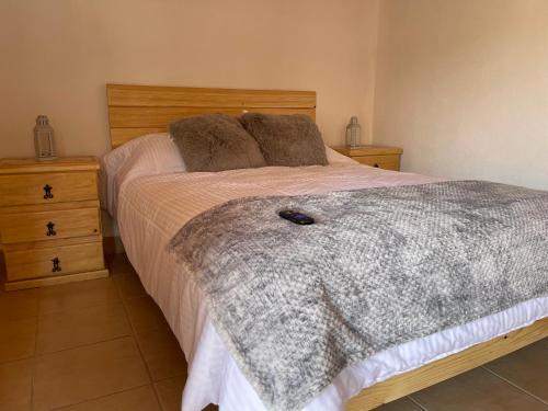 ein Schlafzimmer mit einem Bett mit einem hölzernen Kopfteil in der Unterkunft Casa Valentino Trattoria & Alojamiento in Mineral del Monte