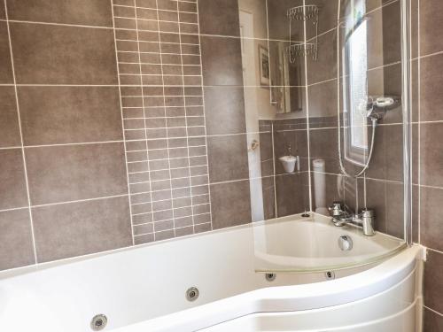 uma casa de banho com uma banheira e um lavatório em Wainwright Lodge em Windermere