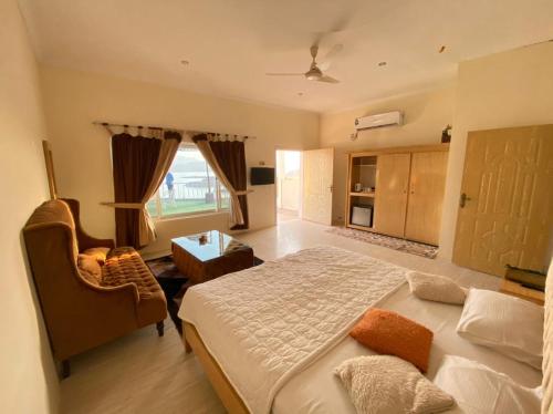ein Schlafzimmer mit einem großen Bett und einem Stuhl in der Unterkunft Gandhara castle hotel Resort & Adventure Club in Khanpur