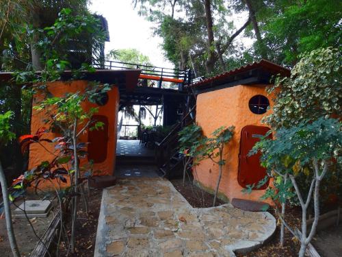 an orange house with a walkway in front of it at Hostería Ecológica El Faro in Salinas