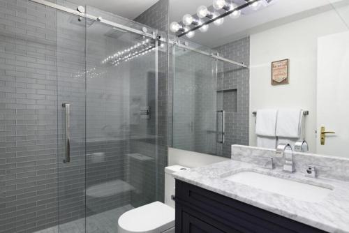 uma casa de banho com um chuveiro, um lavatório e um WC. em Chateau Snow Unit 202, Renovated Condo with Great Natural Light, Excellent Location em Aspen