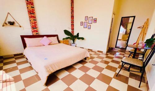 a bedroom with a bed and a checkered floor at Nụ Cười Xinh in Da Lat