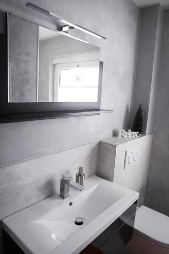 a white bathroom with a sink and a mirror at Ferienwohnung Panoramablick-Rhön in Sandberg