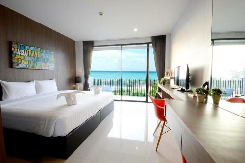 a bedroom with a large bed with a view of the ocean at The Wind Hotel in Bang Sare