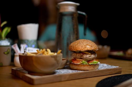 a hamburger and a bowl of fries on a table at Murex Dive Resort in Manado