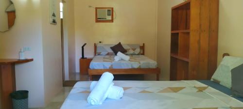 a hotel room with two beds with white sheets at JPH Resort in Malapascua Island