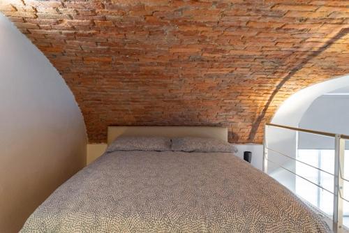 una camera da letto con un muro di mattoni e un letto di La Baby a Torino