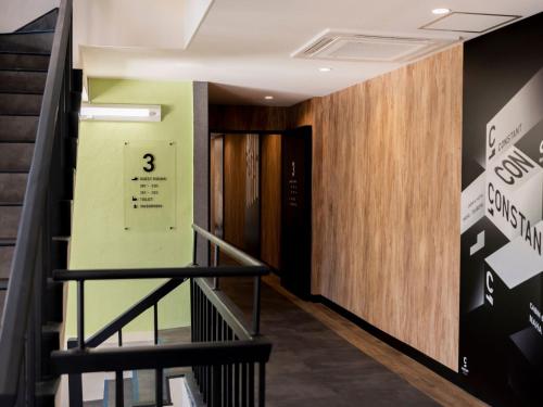 a hallway of a building with a staircase and a door at CABIN&HOTEL CONSTANT NAHA in Naha