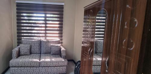 a living room with a chair and a dresser at Heimat Guesthouse in Welkom
