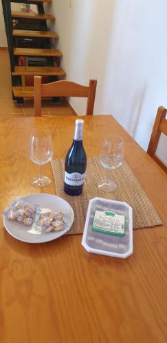 a table with a bottle of wine and two glasses at ATICOS Primera Linea en ZAHARA DE LOS ATUNES in Zahara de los Atunes