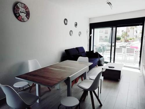 a living room with a wooden table and chairs at Le petit nid de Xanie in Orihuela