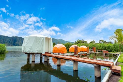 a group of tents on a dock on a body of water at Jempana View in Kintamani