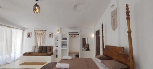 uma sala de estar branca com uma mesa e um sofá em Greek "Jungle Villa", Thalassa Road, Standing alone 3bhk villa with pool em Siolim