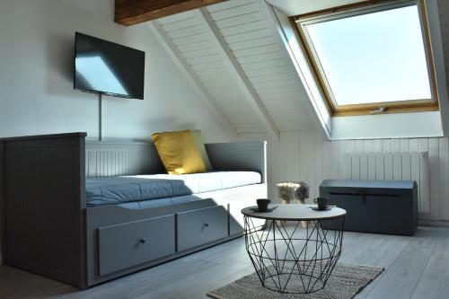 Zimmer mit einem Bett, einem TV und einem Tisch in der Unterkunft Charmant studio, le petit gris des montagnes in Mouthe