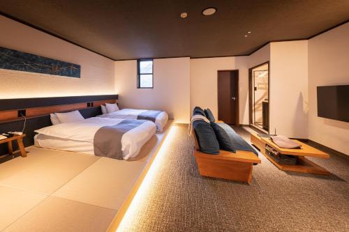 a bedroom with a large bed and a tv at Ryokan Nushiya in Gotsu