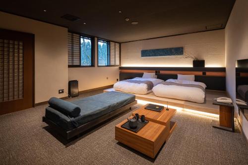a large bedroom with two beds and a couch at Ryokan Nushiya in Gotsu