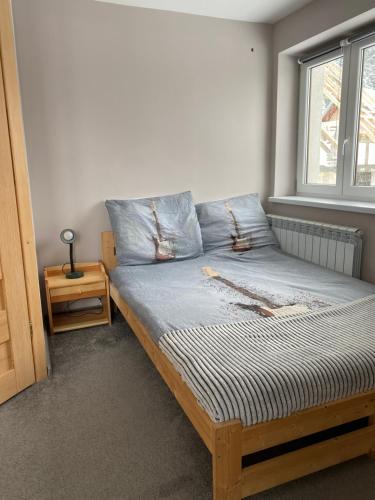 uma cama num quarto com uma janela em Nocleg pod Turbaczem em Nowy Targ