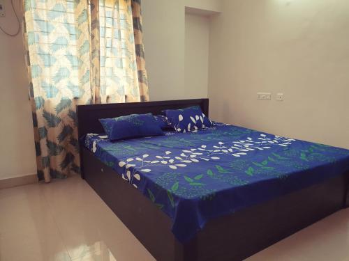 Un dormitorio con una cama con un edredón azul. en Chippy Apartments 3006B, en Chennai