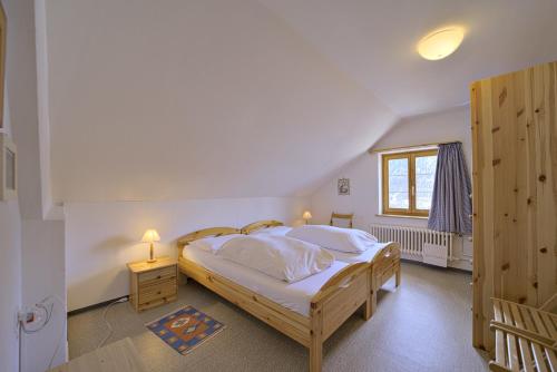 a bedroom with a large bed and a window at Chesa Giandains - Pontresina in Pontresina