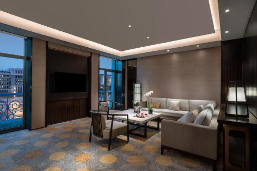 a living room with a couch and a table at Beijing Hotel NUO Forbidden City in Beijing