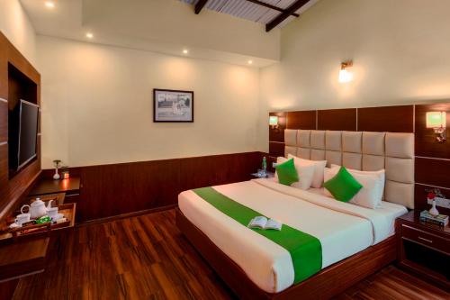 a bedroom with a large bed and a television at Rosewood by Nature Resorts and Stays in Ooty
