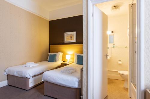 イフラクームにあるDilkhusa Grand Hotel by Compass Hospitalityのベッド2台とバスルームがあるホテルの部屋