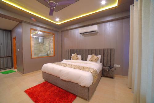 a bedroom with a large bed with a red rug at Yogved Hospitality & Resort in Rishīkesh