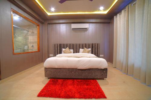 a bedroom with a large bed with a red rug at Yogved Hospitality & Resort in Rishīkesh