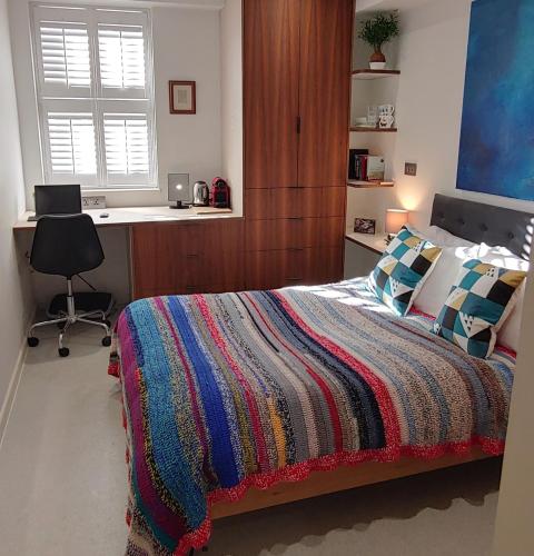 a bedroom with a bed and a desk with a computer at Comfortable Room With Ensuite in London