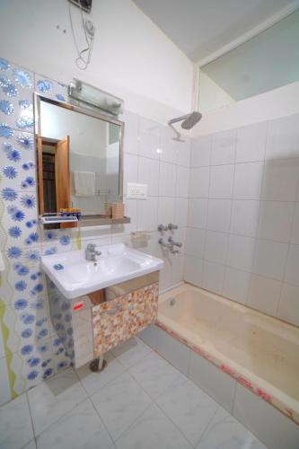 a bathroom with a sink and a bath tub at Yogved Hospitality & Resort in Rishīkesh