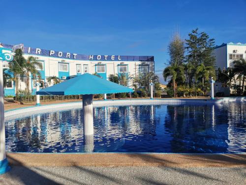 a large pool with an umbrella in front of a hotel at Airport Hotel Clark in Angeles