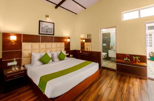 a bedroom with a large bed and a bathroom at Rosewood by Nature Resorts and Stays in Ooty