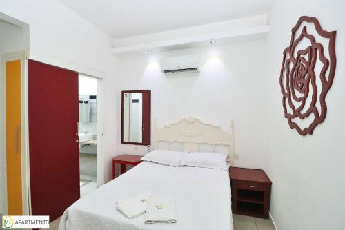Habitación blanca con cama y espejo en Studio silencioso para 3 pessoas em Copacabana, en Río de Janeiro