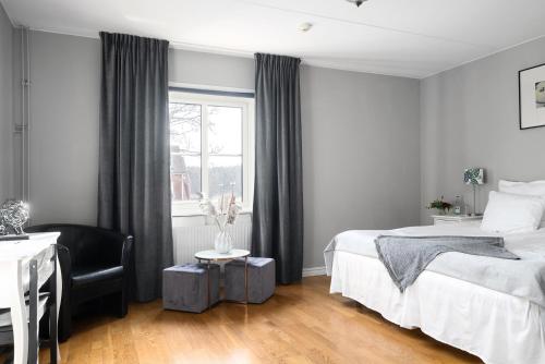 a bedroom with a bed and a desk and a window at Häringe Slott in Västerhaninge