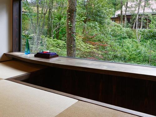 a window sill with a vase and a book on it at Ryokan Nushiya in Gotsu