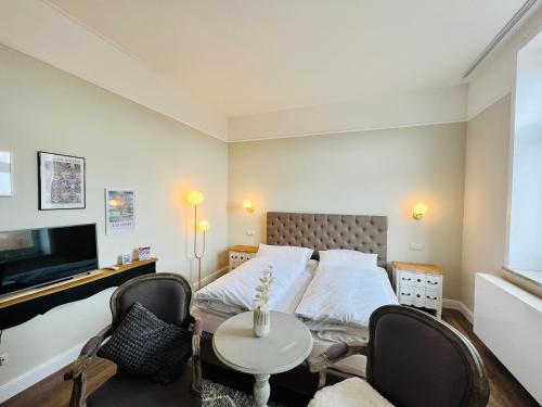 1 dormitorio con 1 cama, mesa y sillas en Lexow - Hotel an de Havenkant, en Tönning