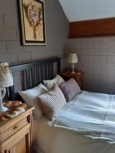 a bedroom with a bed with pillows on it at Le refuge in Hastière-par-delà