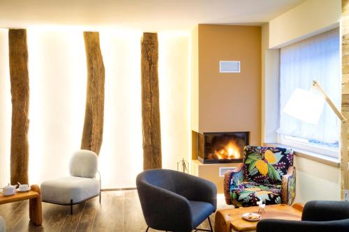 a living room with a couch and chairs and a fireplace at Hirondelle Locanda in Aosta