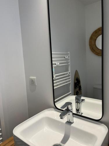 La salle de bains est pourvue d'un lavabo et d'un grand miroir. dans l'établissement Maisonnette à proximité plage et port de St-Martin, à Saint-Martin-de-Ré