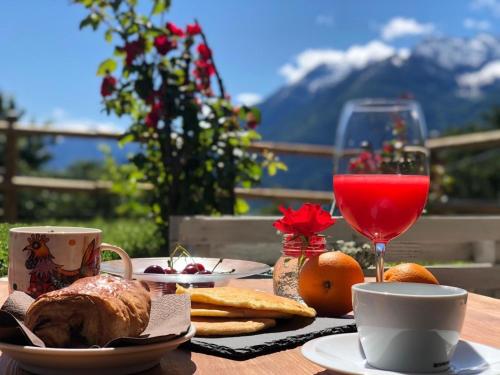 a table with food and a glass of red wine at Hirondelle Locanda in Aosta