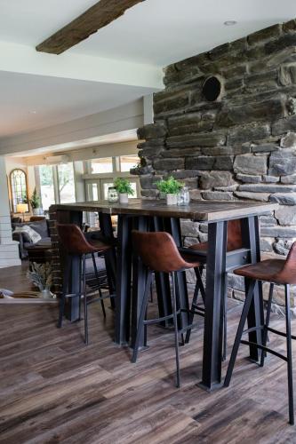 a dining room with a stone wall and a table and chairs at Mountain Meadows Lodge in Killington