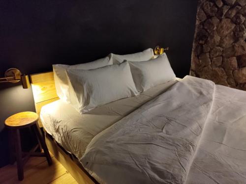 Bett mit weißer Bettwäsche und Kissen in einem Zimmer in der Unterkunft Camellia 2022 in Jiufen
