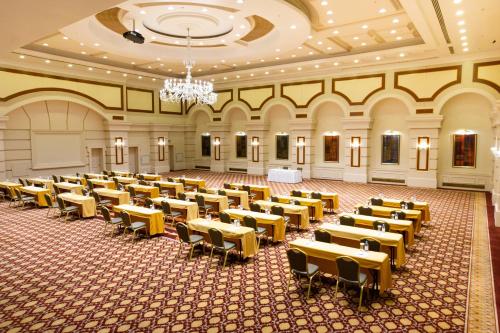 an empty banquet hall with tables and chairs at Rixos President Hotel Astana in Astana
