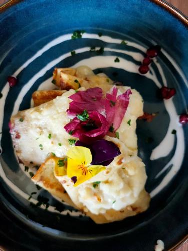 a blue plate of food with flowers on it at Hirondelle Locanda in Aosta