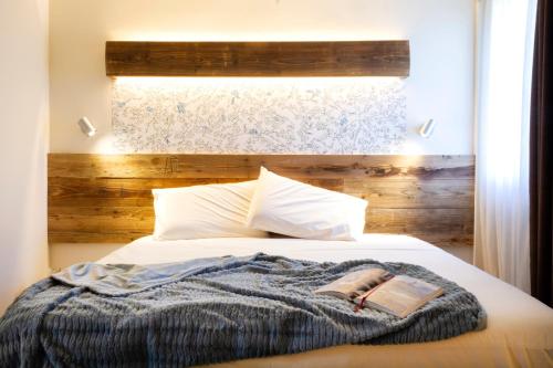 a bedroom with a bed with a blanket and a window at Hirondelle Locanda in Aosta
