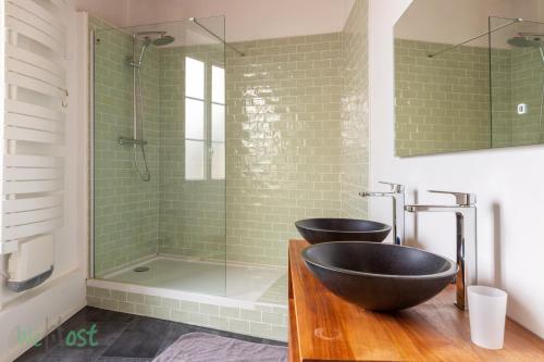 une salle de bain avec deux lavabos et une douche dans l'établissement Coulmiers Bleu - gare SNCF à 5 min, atypique & confort, à Nantes